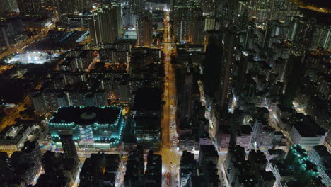 nighttime aerial view of high-rise cityscape and glowing city grid in hong kong
