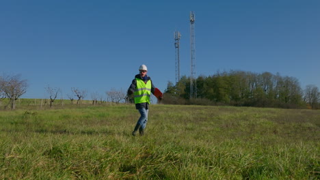 Heading-towards-industrial-pylons,-safety-conscious-employee-gives-directions