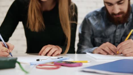 close up view of happy diverse multi-ethnic students or young business team working on a project or writing a test. slow motion