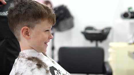 Hair-stylist-cutting-hair-of-boy-in-salon