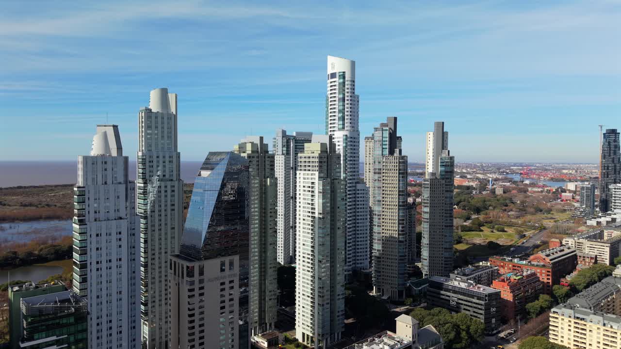 Stunning aerial drone footage of the modern Puerto Madero skyline in Buenos Aires, Argentina. The shot reveals impressive skyscrapers and high-rises on a sunny day