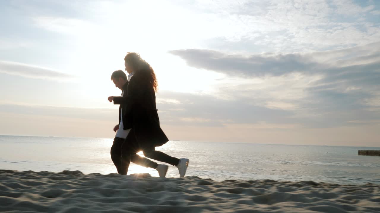 모래 해변에서 달리는 젊은 커플, 재미있는 커플, 속임수, 손을 잡고, 즐거운 순간, 봄 여행 휴가 휴가 신혼여행 동안 만적 인 일몰, 놀이 소녀와 사랑에 빠진 남자