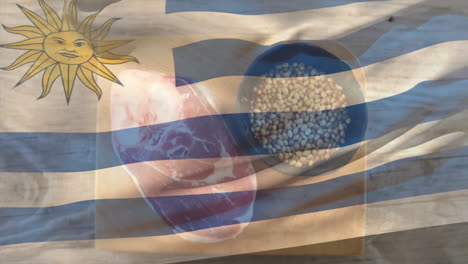 uruguay flag overlaying raw meat and grains in bowl on wooden surface