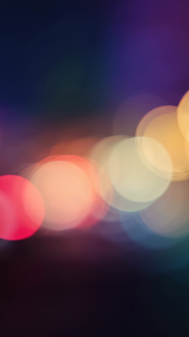 Vertical video: Playback starting blurred lights dancing across night scene, with colorful bokeh