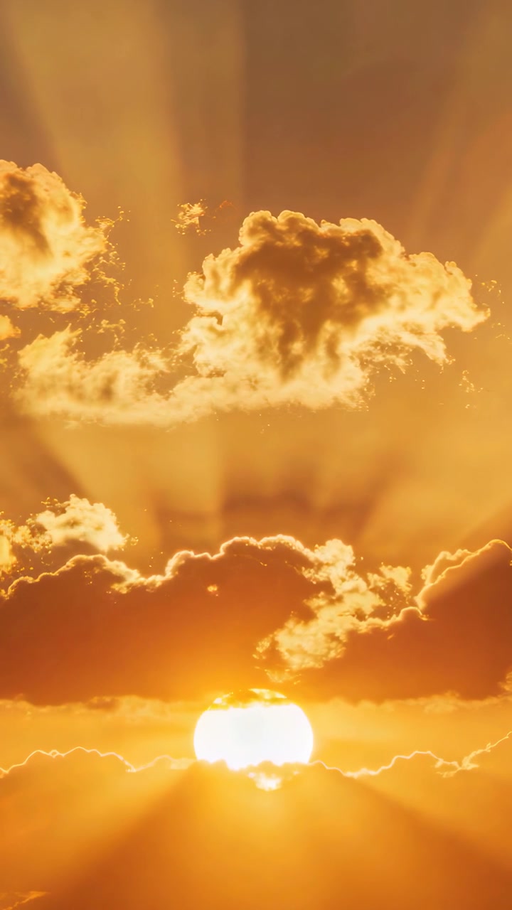 Vertical video: Flickering sun near horizon shifting glow with drifting clouds, casting golden rays