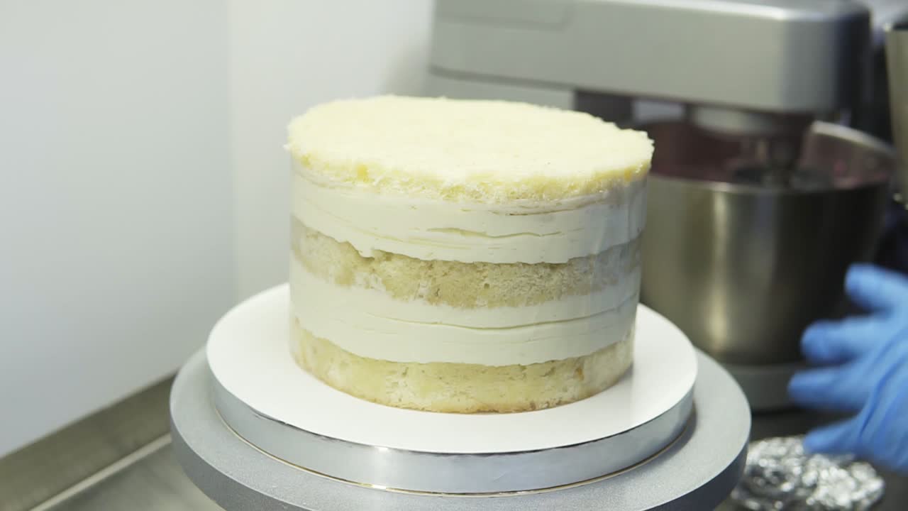 Confectioner takes the baking tin off the biscuit cake. Process of creating beautiful delicious cake. Food art.