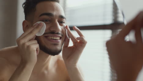 man applying facial cleansing pads