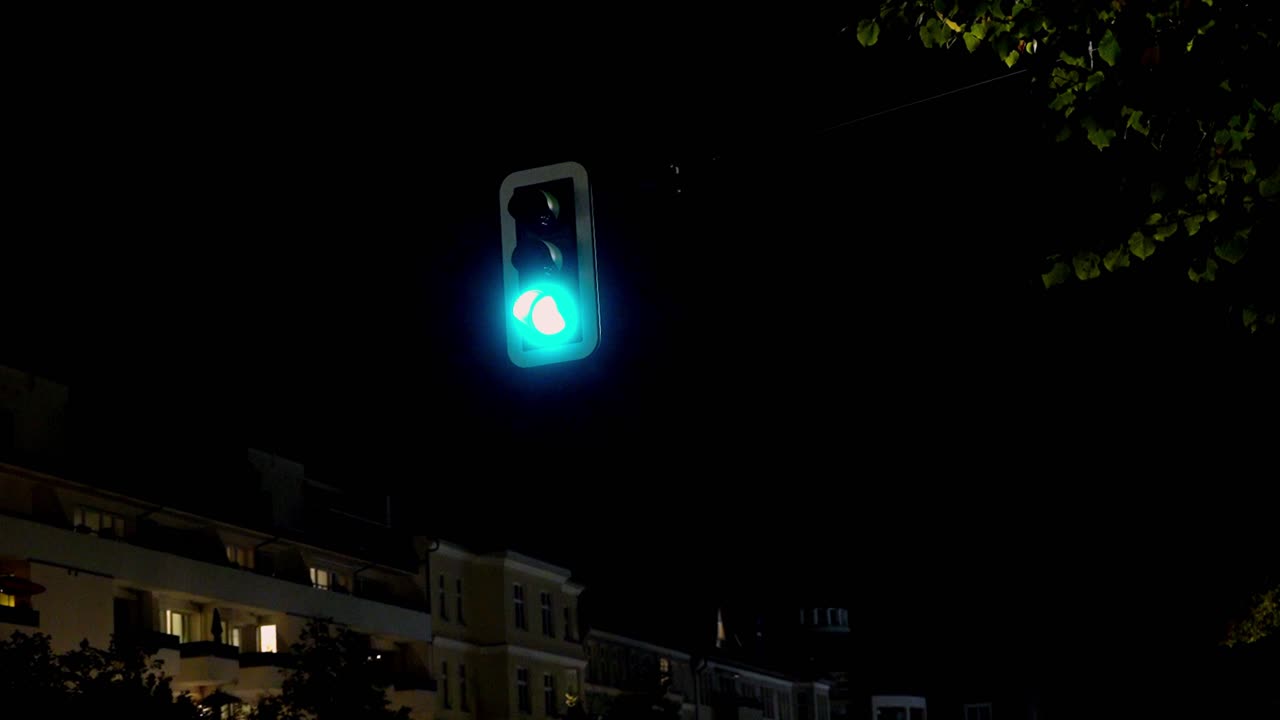 German traffic light switching from red to yellow to green at night in the city of Berlin