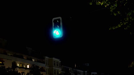 german traffic light switching from red to yellow to green at night in the city of berlin