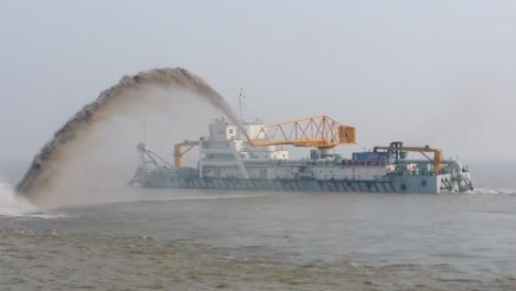 dredging vessel in action to keep waterways navigable, excavate and gathering sediments in the bottom and disposing at another location, shanghai river, china