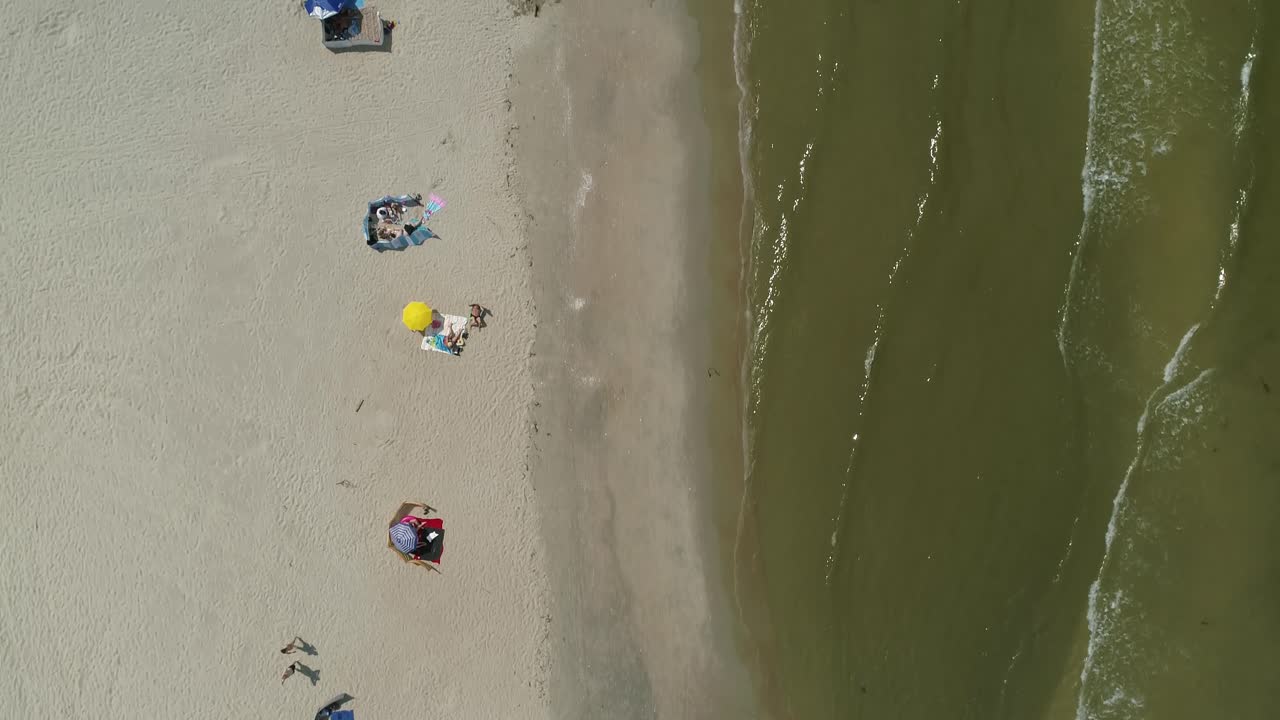 발트해 연안의 해변에 있는 사람들은 목욕과 일광욕을 하고 있습니다.