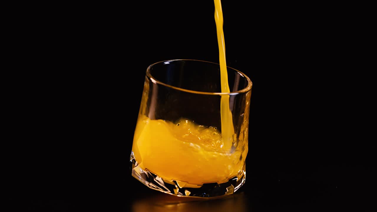Succo d'arancia versato in un bicchiere inclinato