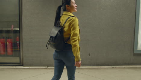 Woman-Wearing-Backpack-Getting-Off-Underground-Train-Onto-Station-Platform