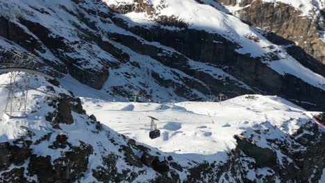 Aerial-view,-Gondola-In-a-Swiss-alps-mountain-to-transport-skiers-and-winter-sports-enthusiasts