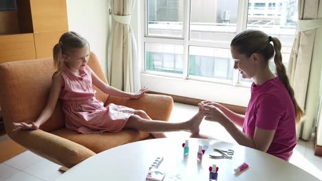 madre haciendo una pedicura a su hija