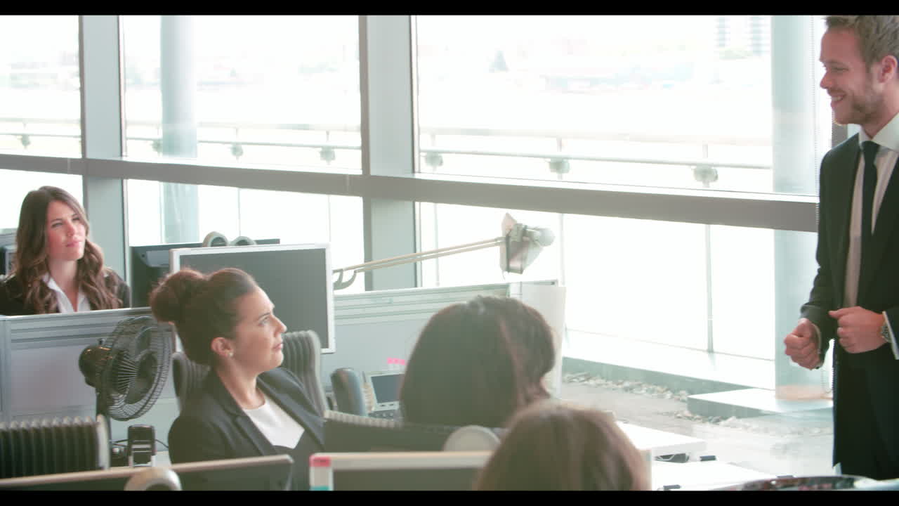 비즈니스 동료들은 바쁜 사무실에서 대화하고 있습니다.