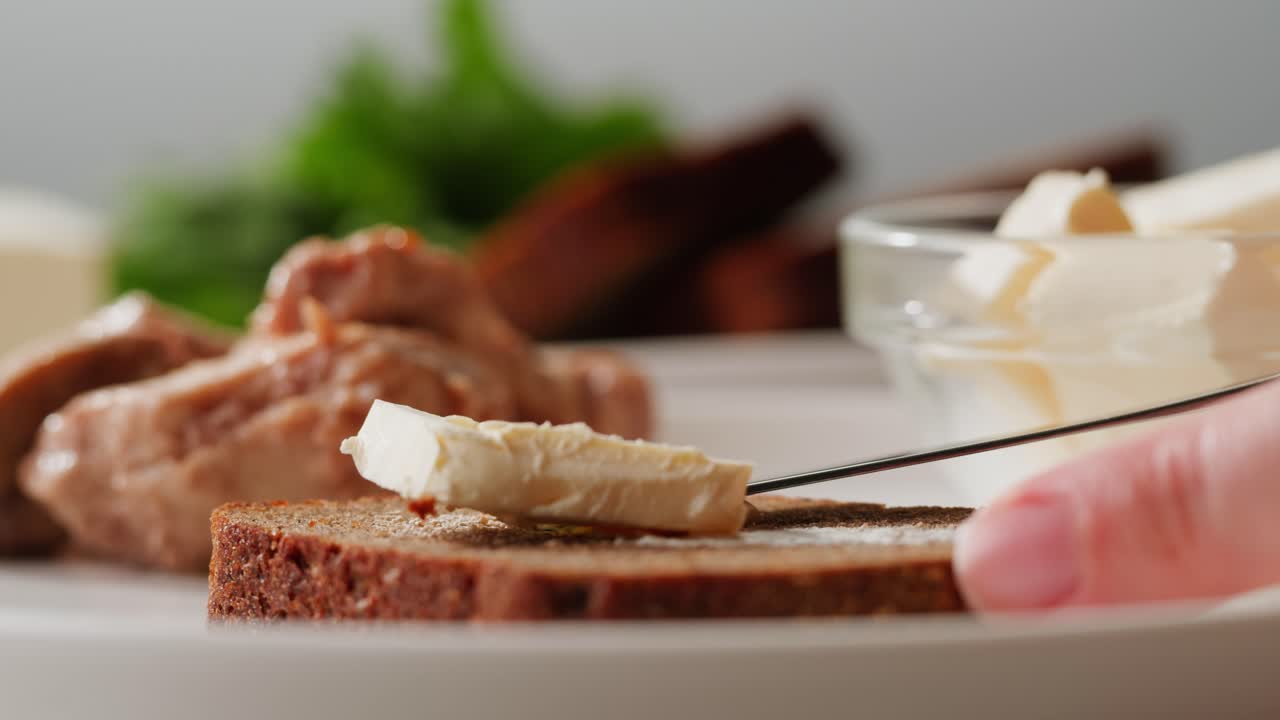 Young woman spreading nut butter onto toast in kitchen, closeup. High quality 4k footage