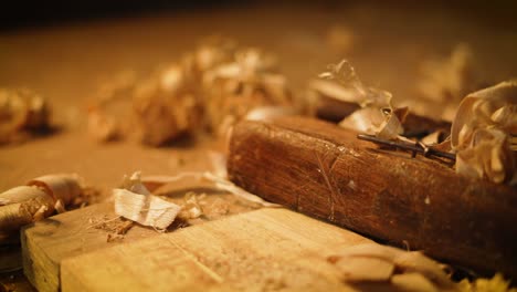 wood planer lying in a carpenter workshop with wood waste, carpenter picking up the planer, closeup of carpenting tools, process of making wood furniture