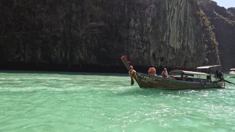 un barco navegando por las aguas esmeraldas cerca de altos acantilados