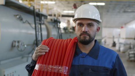 slowmo of plant worker carrying hdpe pipes