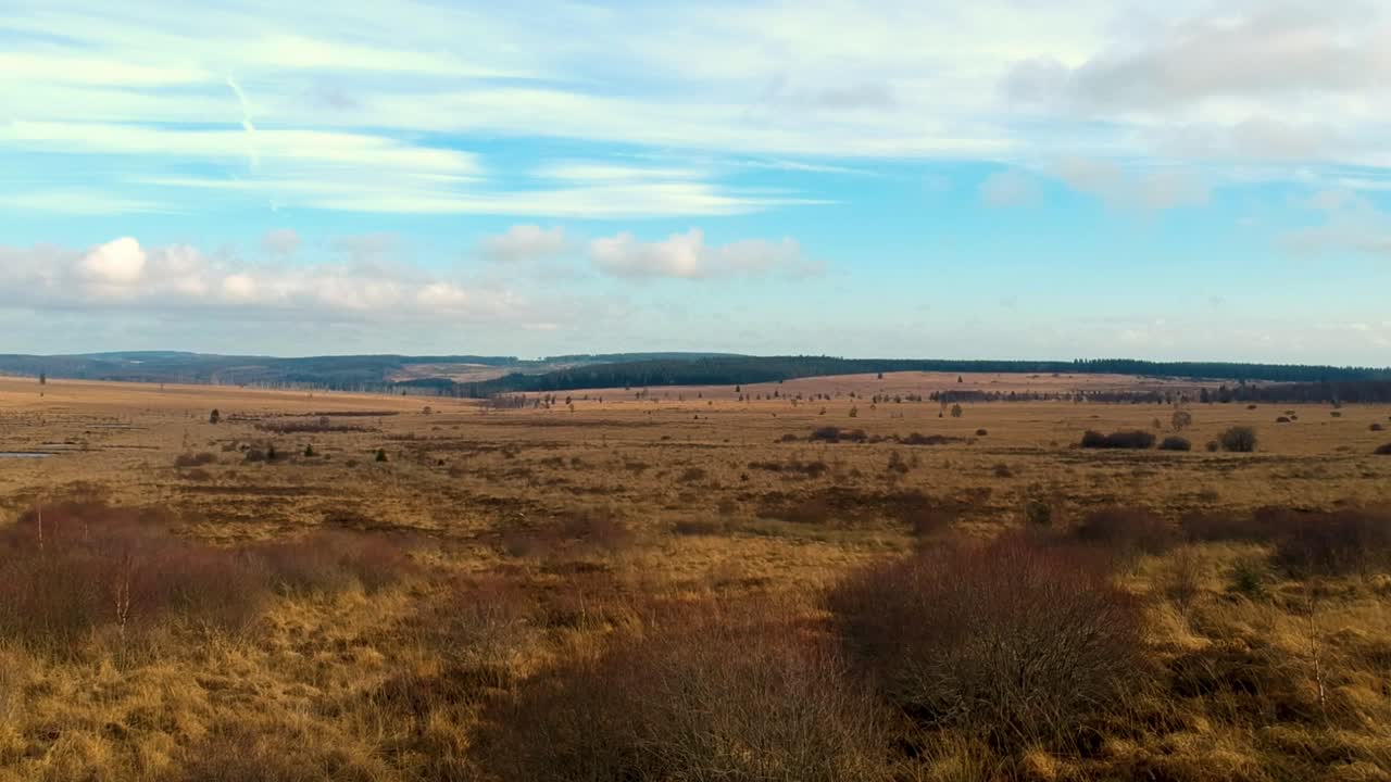 Aerial push out marshland valley clouds blue sky colorful landscape