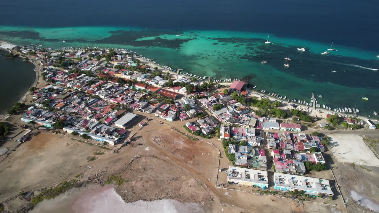 Colorful coastal town by the sea with boats and turquoise waters in los roques, aerial view