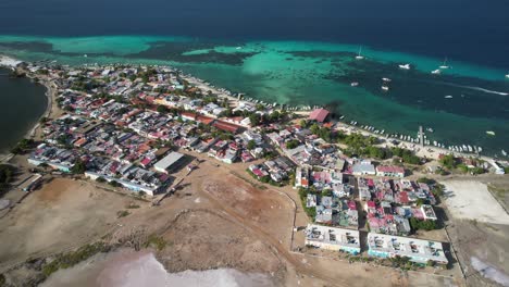 colorful coastal town by the sea with boats and turquoise waters in los roques, aerial view