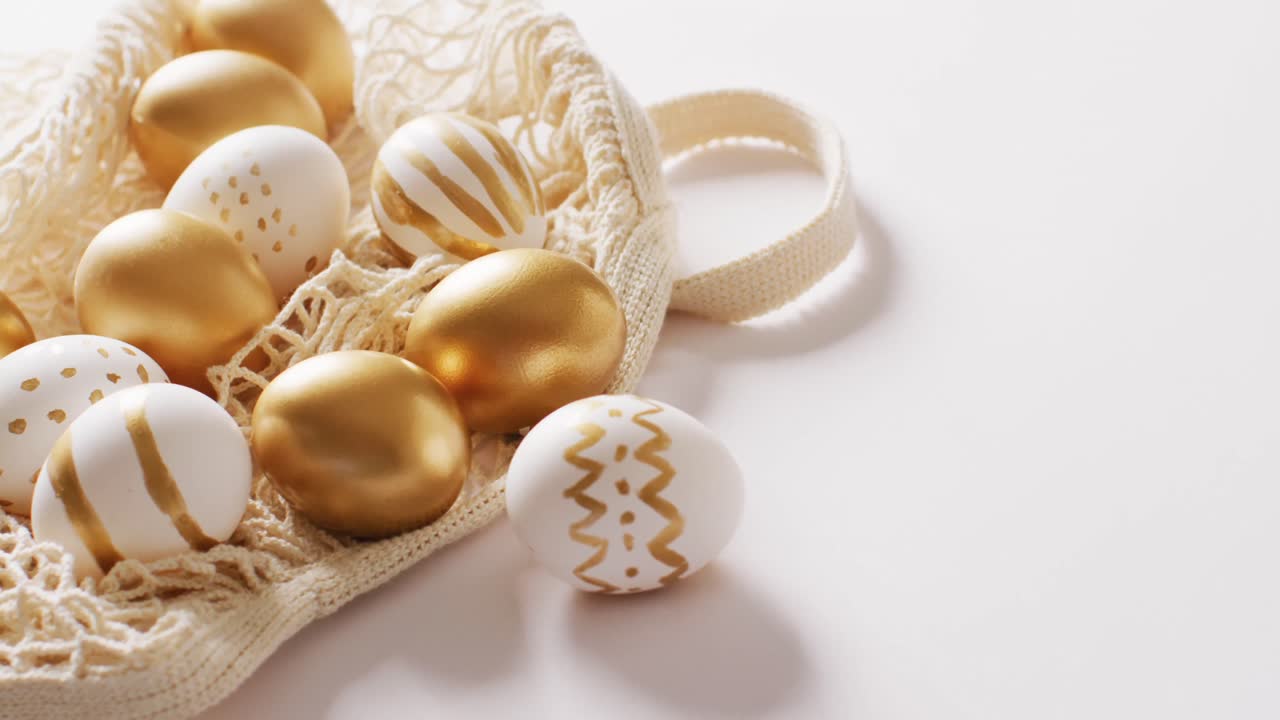 Bag with white and gold easter eggs on white background with copy space