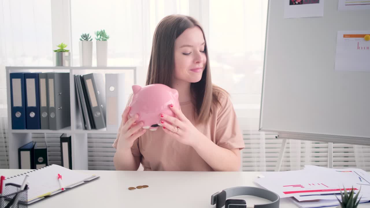 젊은 여성 손으로 돈 동전을 돼지 은행에 넣는