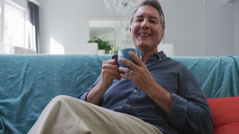 Retrato-De-Un-Feliz-Hombre-Caucásico-Mayor-Sentado-En-La-Sala-Bebiendo-Café-Y-Sonriendo