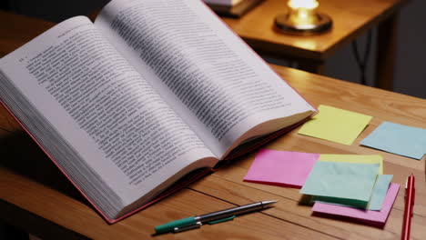 open book with sticky notes and pens on a desk