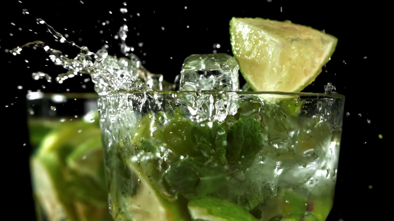 Hidastettuna jää ja lime loiskahtavat Mojito-juomaan.