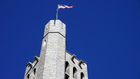 gothic bell tower with american flag and parapet.