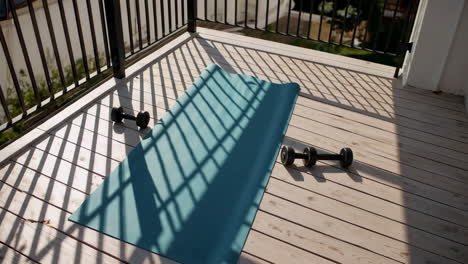 outdoor workout on balcony with yoga mat and dumbbells