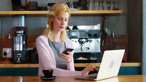 woman using her laptop and her phone