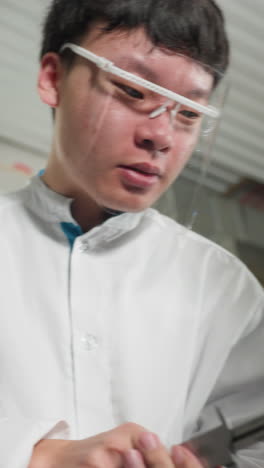 자동차 작업장에서 엔진 부품을 측정하기 위해 베르니에 칼리퍼를 사용하는 안전 안경을 착용한 실험실 코트 전문의 근접 사진