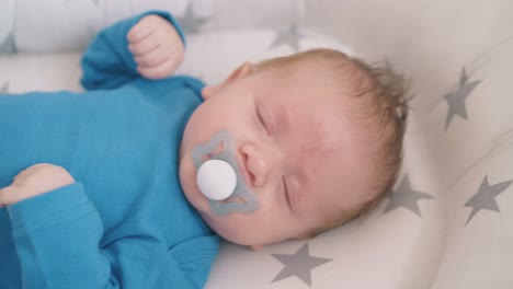 little-child-sucks-dummy-falling-asleep-on-rocking-crib