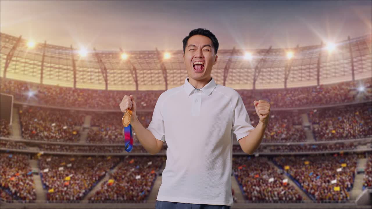 아시아인 남자가 금메달을 바라보며 골을 비명을 지르며 경기장에서 첫 우승을 축하하고 있다.