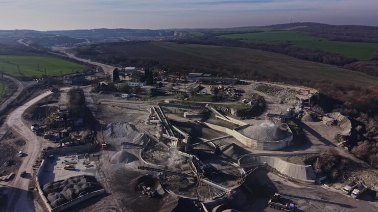 Quarry site activities with machinery and landscape in the distance