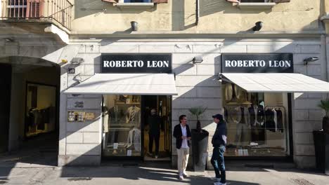 people walking past roberto leon store in milan