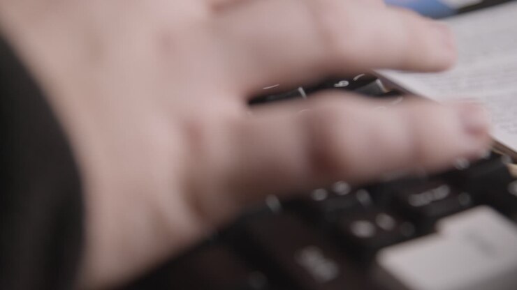 Person Using Keyboard Next To Newspaper Headline Discussing Extreme Weather Conditions And Thunder Storms In Global Warming Crisis