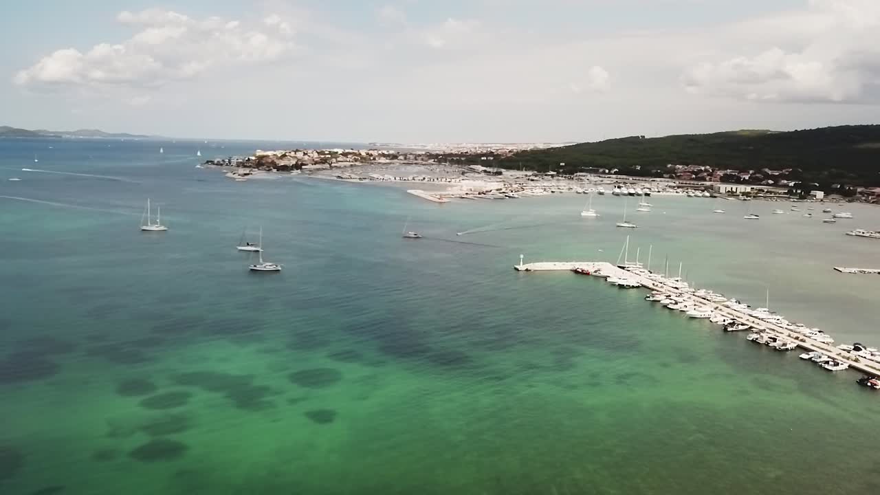 Záběry z dronu zachycující krásnou chorvatskou zátoku s klidnými tyrkysovými vodami, skalnatými břehy a okolní zelení, zdůrazňující poklidné jadranské pobřeží