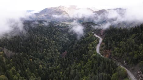 Aerial-shot-of-Fog-passing-through-green-mountains