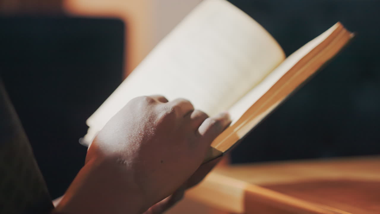 participant fully engrossed in literature, individual intently absorbing information from printed pages, reader entirely absorbed in novel while librarian appreciates quiet atmosphere
