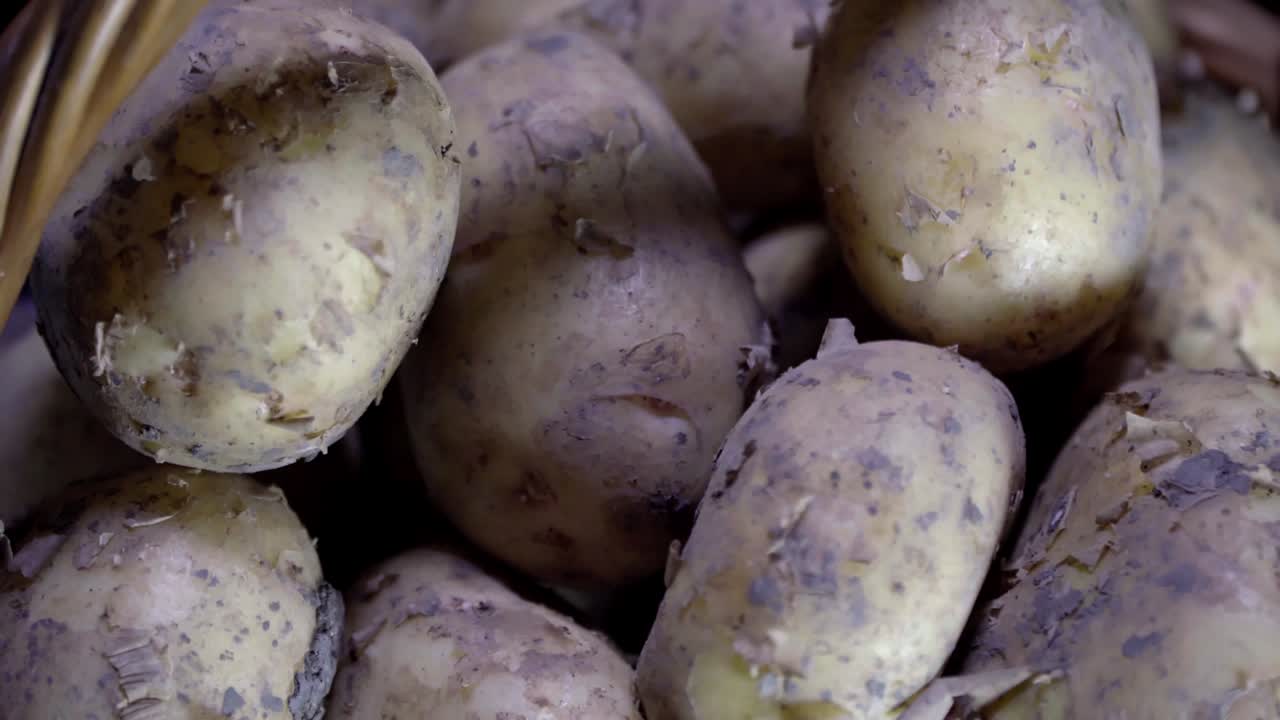 composición de verduras, rotación de una canasta con verduras de raíz, patatas, sobre un fondo negro