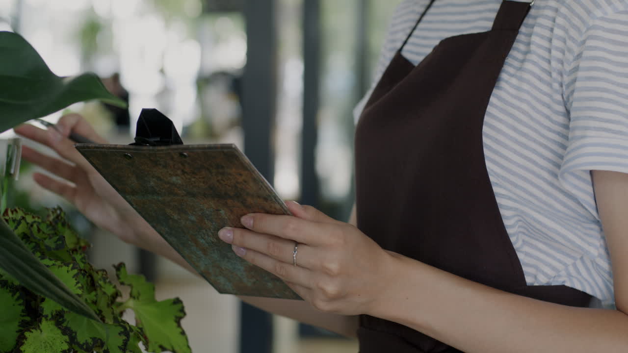 Woman Taking Inventory in a Floral Shop