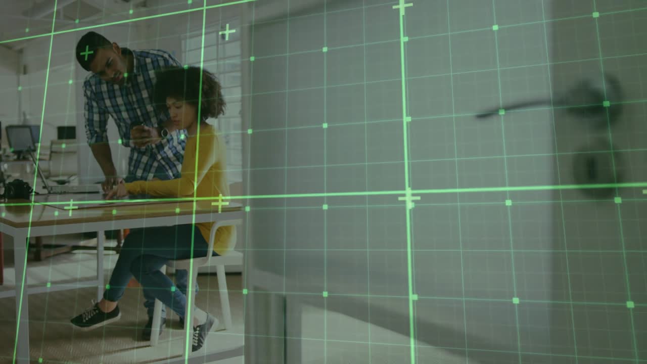 Man and woman working at desk with green grid animation overlay