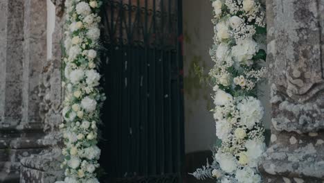 white flower arrangement decorates old stone doorway for wedding ceremony
