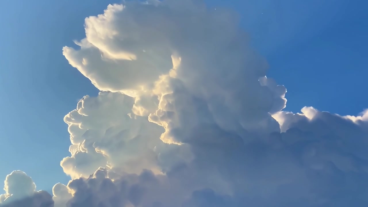 Luce solare dorata che illumina grandi cumuli nel cielo blu