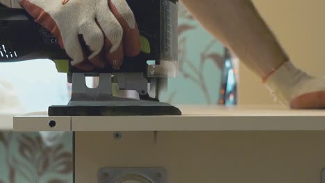 el maestro de la producción de muebles corta la superficie de la mesa con un rompecabezas eléctrico 4 close-up cámara lenta
